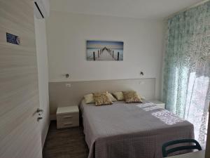 una piccola camera con letto e finestra di B&B EDEN OGLIASTRA a Tortolì
