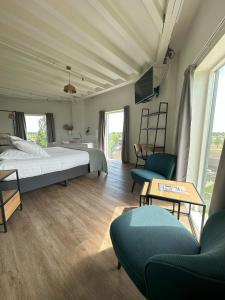 a bedroom with a bed and two chairs and a table at Hotel de Watertoren in Dordrecht