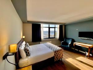 um quarto de hotel com uma cama e um piano em The Han Residence Haliç em Istambul