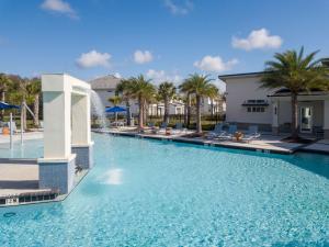 - une piscine avec des palmiers dans un complexe dans l'établissement 5Br 5Bath Pvt Home BBQ Pool 15min Disney 3056ft, à Kissimmee