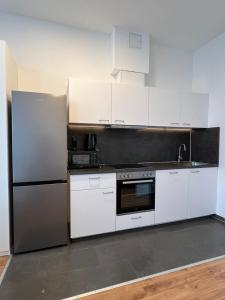 una cucina con armadietti bianchi e frigorifero di Harmony Apartment at U6-Metro Vienna a Vienna