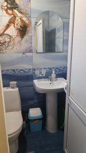 a bathroom with a sink and a toilet and a mirror at Orhidea guest house in Gagra