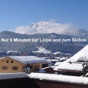 une montagne enneigée au loin avec les mots num 5 min zir hivernal dans l'établissement Haus Christl, à Reit im Winkl