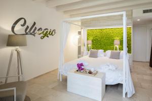 1 dormitorio con 1 cama blanca y un cartel en la pared en San Lorenzo Boutique Hotel & SPA, en Polignano a Mare