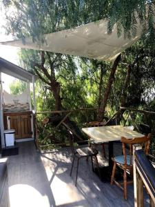 un patio con mesa y sillas en una terraza en Extraordinary Boat House, en Las Zocas