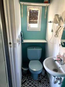 a bathroom with a blue toilet and a sink at Extraordinary Boat House in Las Zocas