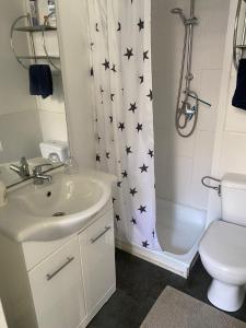 ein Badezimmer mit einem Waschbecken und einem Duschvorhang mit schwarzen Sternen in der Unterkunft Klooster Mariadal Maastricht in Maastricht