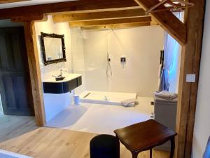 uma casa de banho com um lavatório e uma banheira em Le Gîte de la Grange em La Wantzenau