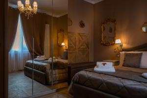 Cette chambre comprend 2 lits et un miroir. dans l'établissement Dolce Casa Villa Laura, à Bologne