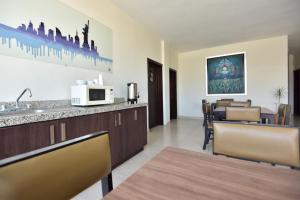 uma cozinha e sala de jantar com uma mesa e um micro-ondas em Bed Bed Hotel Perla em Torreón