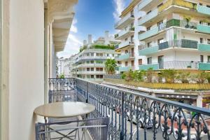 een balkon met een tafel en stoelen en een gebouw bij Magnifique T2 dans l'hyper centre - rue d'Antibes in Cannes