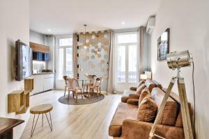 een woonkamer met een bank en een tafel bij Magnifique T2 dans l'hyper centre - rue d'Antibes in Cannes