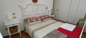 um pequeno quarto com uma cama branca e um cobertor vermelho em Appartamento La Rondine em Pesaro