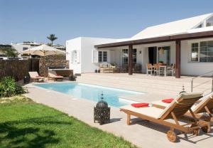 a villa with a swimming pool and a house at Villa Perla in Puerto del Carmen