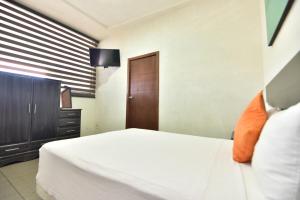um quarto com uma cama branca e um armário de madeira em Bed Bed Hotel Perla em Torreón