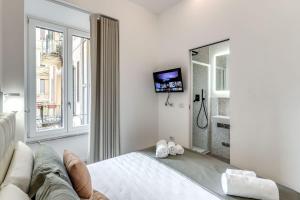 a white room with a bed and a tv at Vatican Portrait Suites in Rome