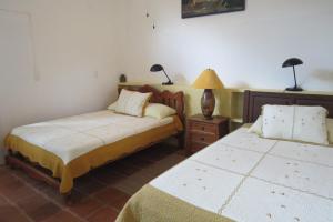 a bedroom with two beds and a lamp on a table at Apartamento Karibu in Manuel Antonio