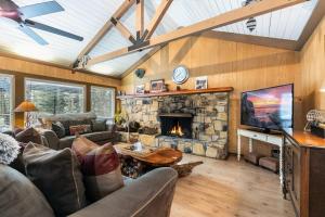 uma sala de estar com lareira de pedra e sofás em Classic 3BD Tahoe Cabin with Hot Tub em Carnelian Bay