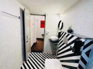 a bathroom with a black and white striped floor at AnandMai Ghar - A Homestay in Gwalior in Gwalior