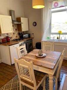 a kitchen with a wooden table and a table and chairs at Beautiful traditional flat in the center of Largs. in Largs