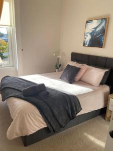 a bedroom with a large bed with pillows on it at Beautiful traditional flat in the center of Largs. in Largs