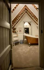 a bathroom with a tub and a large mirror at Chestnut Tree Cottage, 7 High Street in Ardingly +10 photos