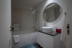 a white bathroom with a sink and a mirror at Sublime Coliseum in Ponta Delgada +28 photos