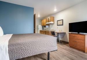 a bedroom with a bed and a kitchen with a desk at Extended Stay America Select Suites - Fort Myers in Fort Myers