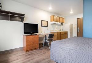 um quarto com uma cama e uma secretária com uma televisão em Extended Stay America Select Suites - Fort Myers em Fort Myers