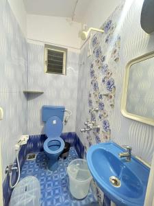 a bathroom with a blue toilet and a sink at HAKUNA MATATA - Best budget stay at Arambol Beach, Goa in Arambol