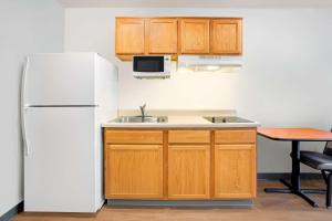 cocina con nevera, fregadero y mesa en Extended Stay America Select Suites - Fort Myers - Northeast en Fort Myers