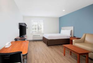 a hotel room with a bed and a desk at Extended Stay America Select Suites - Fort Myers - Northeast in Fort Myers