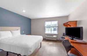 um quarto com uma cama e uma televisão de ecrã plano em Extended Stay America Select Suites - Birmingham - Bessemer em Bessemer