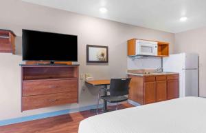Pokój z sypialnią z biurkiem i telewizorem w obiekcie Extended Stay America Select Suites - Colorado Springs w mieście Colorado Springs