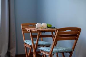 einen kleinen Holztisch mit zwei Stühlen und Äpfeln darauf in der Unterkunft Antalya B&B Hotel in Antalya