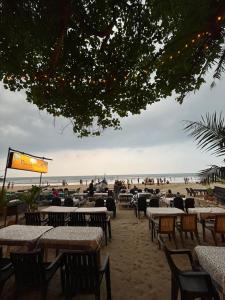 un grupo de mesas y sillas en la playa en HAKUNA MATATA - Best budget stay at Arambol Beach, Goa en Arambol