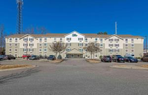 a large building with cars parked in a parking lot at Extended Stay America Select Suites - Atlanta - Alpharetta in Alpharetta