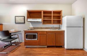 La cuisine est équipée d'un réfrigérateur blanc et d'un évier. dans l'établissement Extended Stay America Select Suites - Atlanta - Alpharetta, à Alpharetta