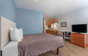 a hotel room with a bed and a television at Extended Stay America Select Suites - Austin - Northwest in Jollyville