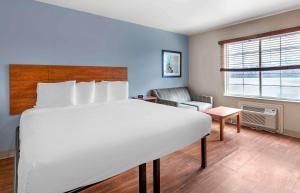 a bedroom with a white bed and a living room at Extended Stay America Select Suites - Austin - Northwest in Jollyville
