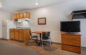 a small kitchen with a small table and a television at Extended Stay America Select Suites - Austin - Northwest in Jollyville