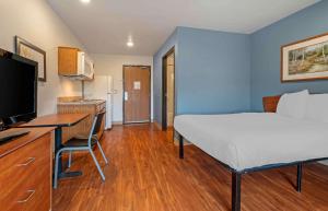 a bedroom with a bed and a desk with a computer at Extended Stay America Select Suites - Indianapolis - Greenwood in Greenwood