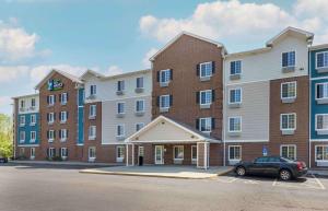 a large brick building with a car parked in a parking lot at Extended Stay America Select Suites - Akron - South in Portage Lakes