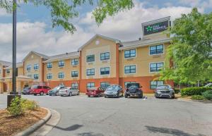 a large building with cars parked in a parking lot at Extended Stay America Suites - Charlotte - Pineville - Park Rd in Charlotte