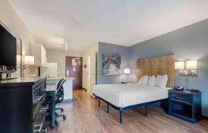 a hotel room with a bed and a desk and a kitchen at Extended Stay America Suites - Charlotte - Pineville - Park Rd in Charlotte