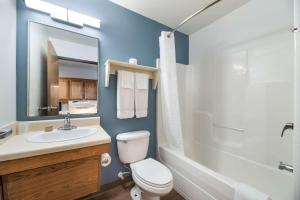 a bathroom with a toilet and a sink and a tub at Extended Stay America Select Suites - Bentonville in Bentonville