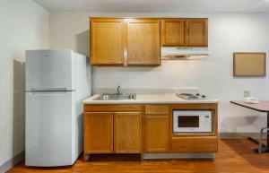 uma cozinha com um frigorífico branco e um lavatório em Extended Stay America Select Suites - Akron - South em Portage Lakes