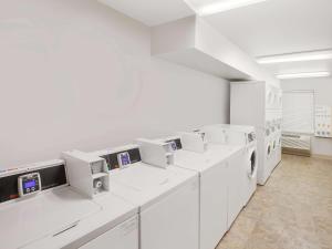 a large white laundry room with white machines at Extended Stay America Select Suites - Bentonville in Bentonville
