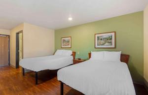 twee bedden in een kamer met groene muren bij Extended Stay America Select Suites - Cleveland - Mentor in Mentor