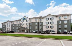a large building with cars parked in a parking lot at Extended Stay America Select Suites - Beaumont in Beaumont